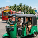 Un tuk tuk vert transportant deux touristes conduit par un chauffeur local dans une rue animée de Colombo Sri Lanka