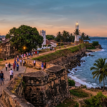 Une photographie de paysage grand angle du Fort de Galle au Sri Lanka au coucher du soleil Les remparts historiques en pierre serpentent le long de la côte avec le phare blanc sur un promontoire et la vieille ville hollandaise sur la gauche