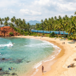 Vue panoramique dune plage tropicale au Sri Lanka avec du sable doré des cocotiers sur une colline rouge des pêcheurs sur échasses et locéan Indien turquoises